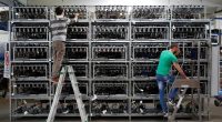 Employees work on bitcoin mining computers at a factory in Florence. Alessandro Bianchi / Reuters